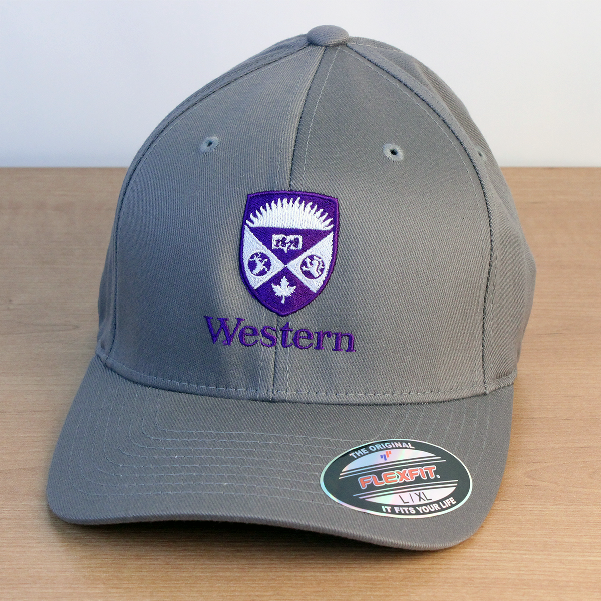 Grey ball cap with a purple and white embroidered Western Crest on the front. 