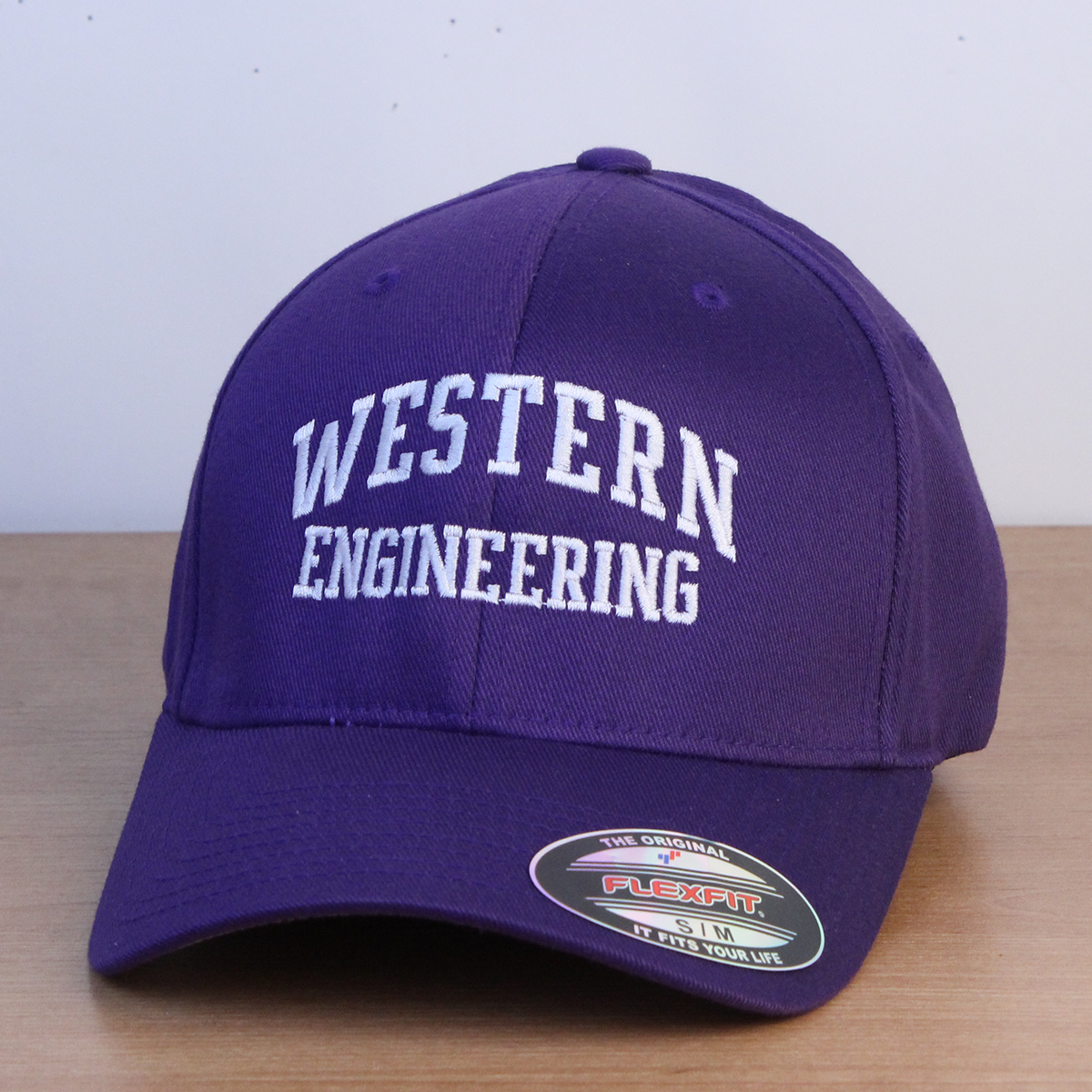 Purple ball cap with Western Engineering embroidered in white lettering.