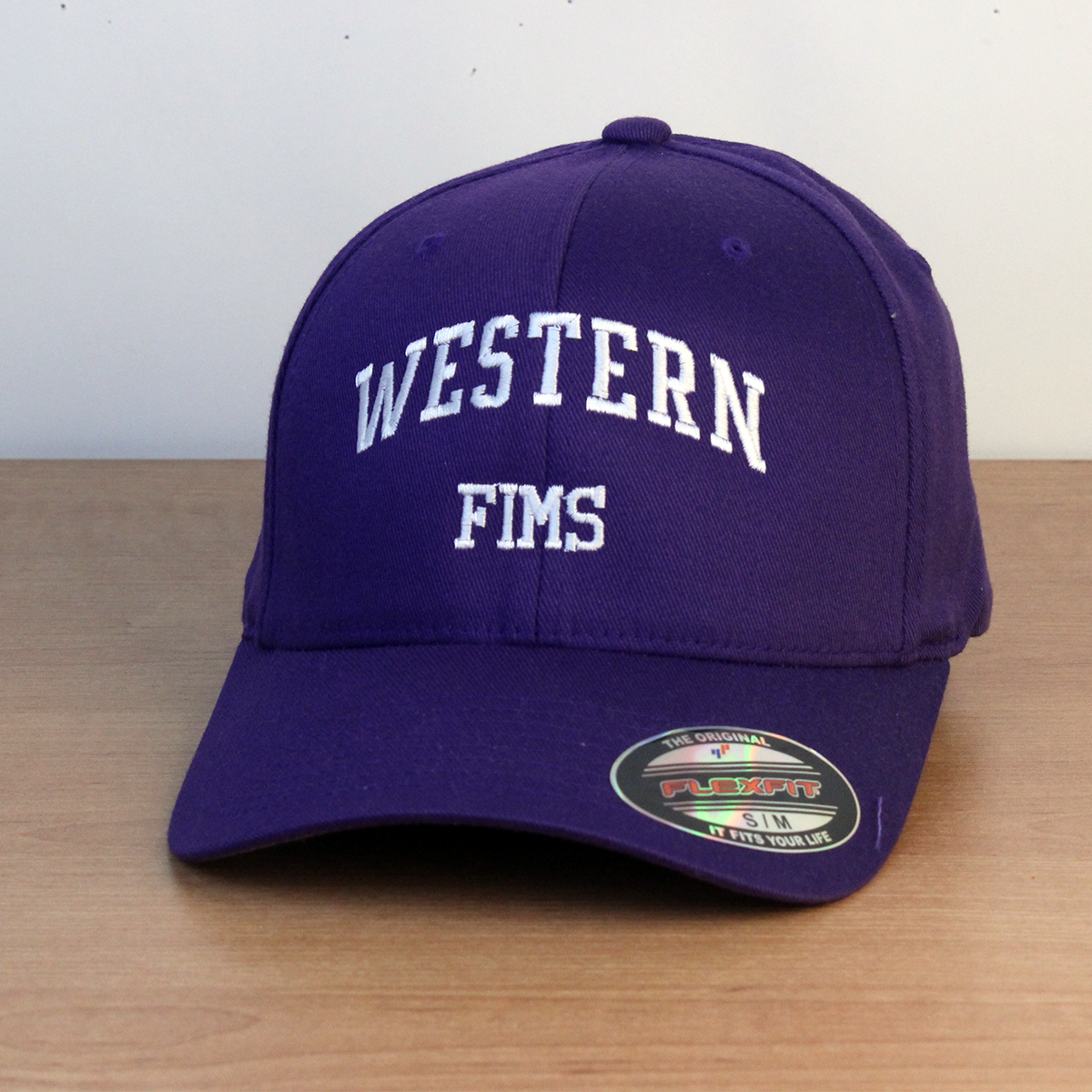 Purple ball cap with Western FIMS embroidered onto the front in white lettering. S/M sizing.