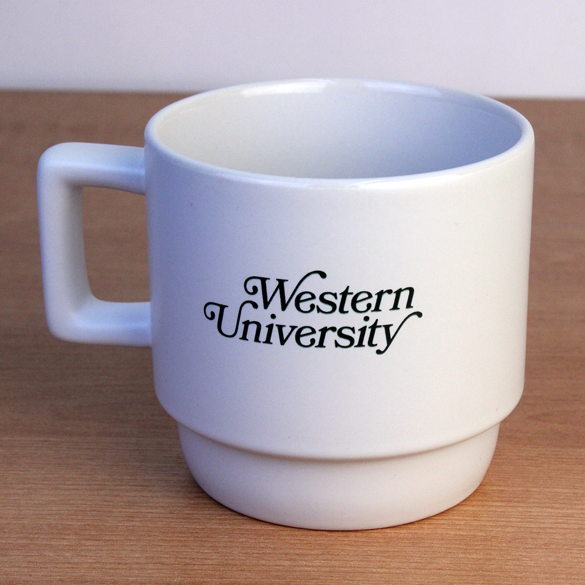 White mug with Western University lettering on the front in green script.