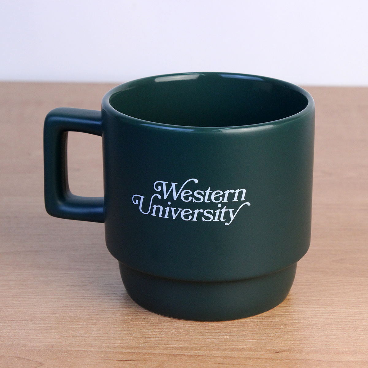 Green mug with Western University written on the front in white script.