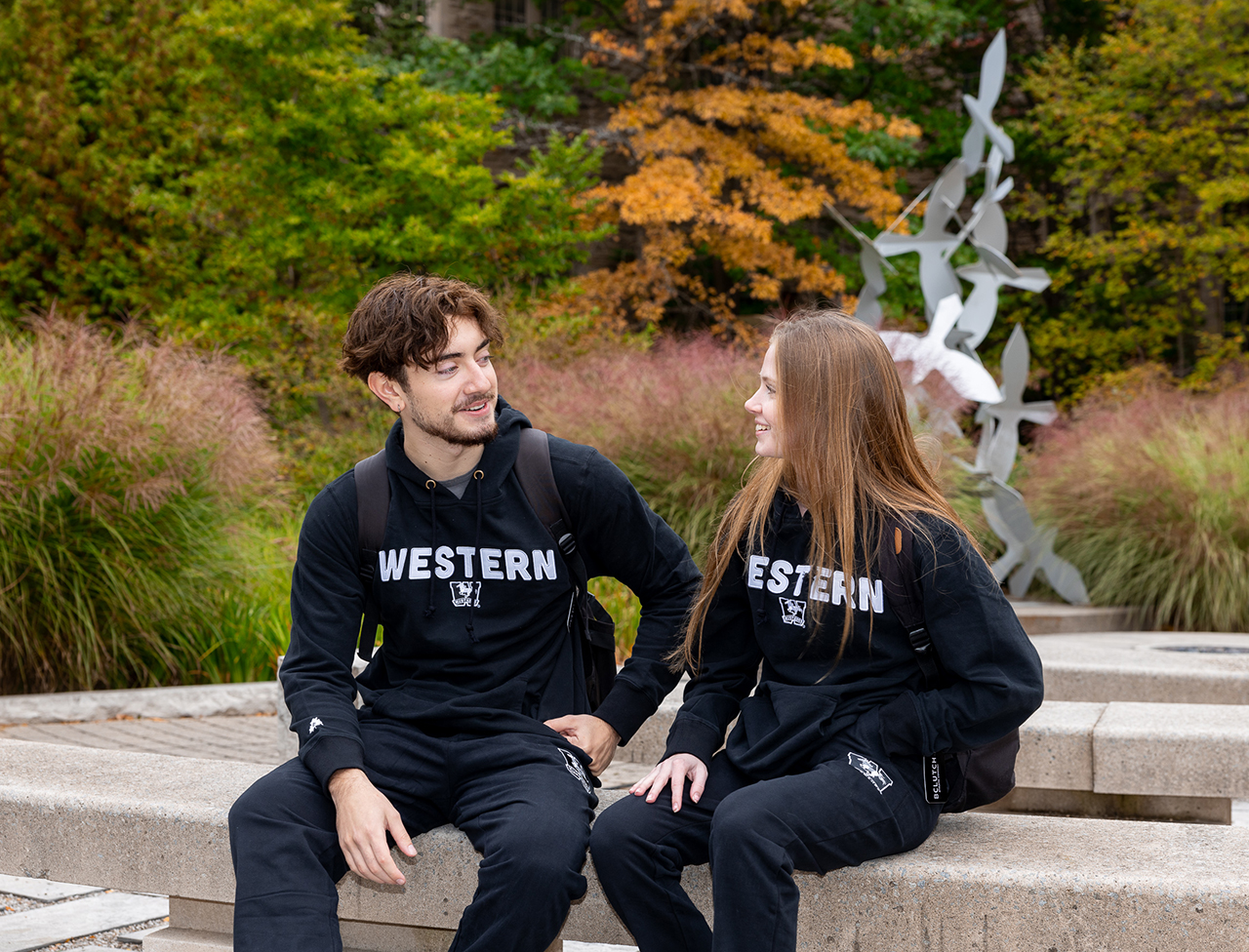 A man and woman wearing western branded athletic wear