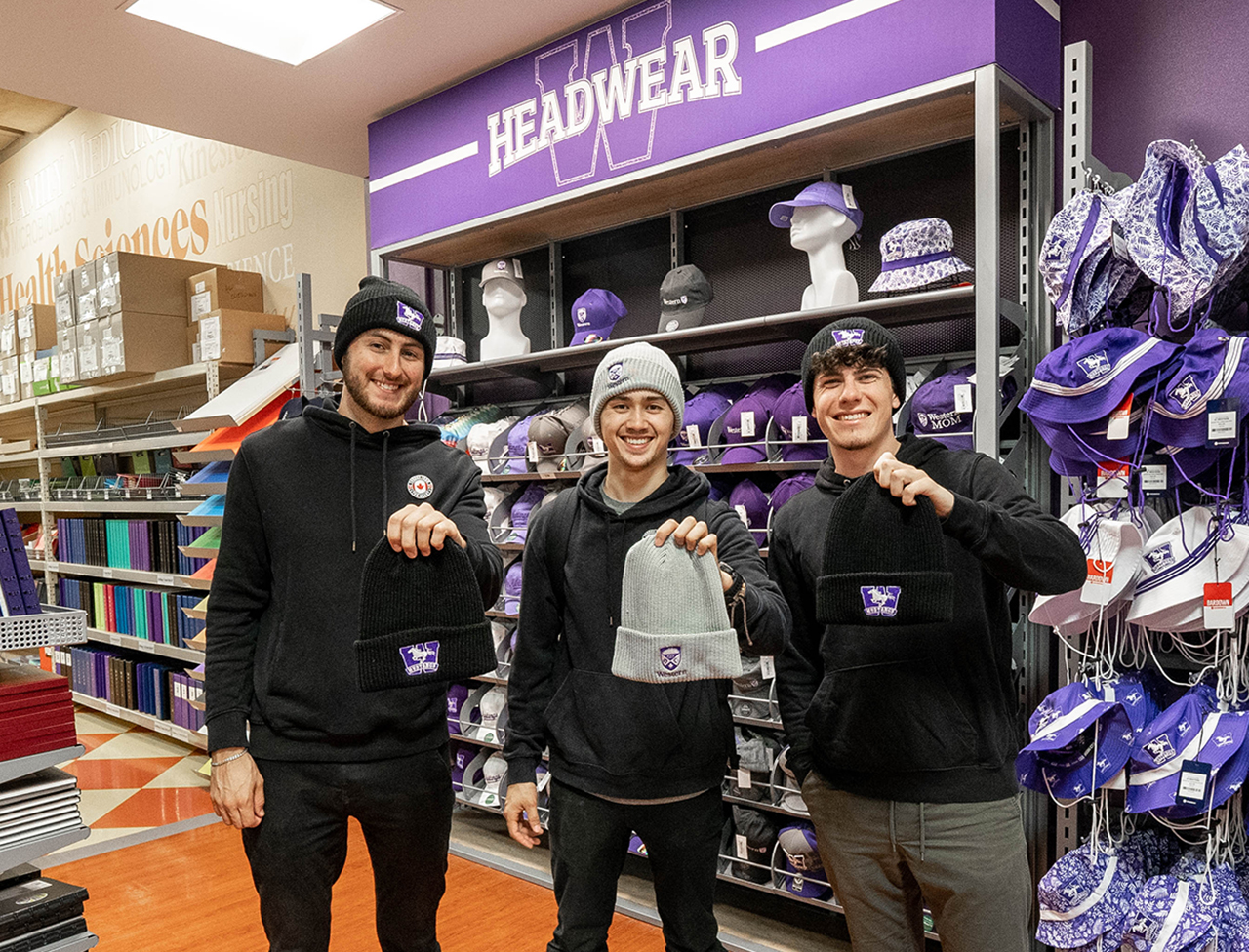 Three men showing western branded touques