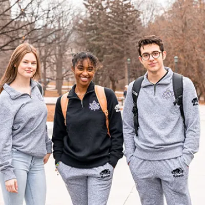 Two woman and a man wearing western branded roots clothing