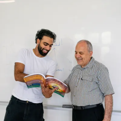 student and professor looking at textbook