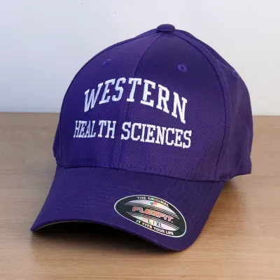 Purple ball cap with Western Health Sciences embroidered onto the front in white lettering.