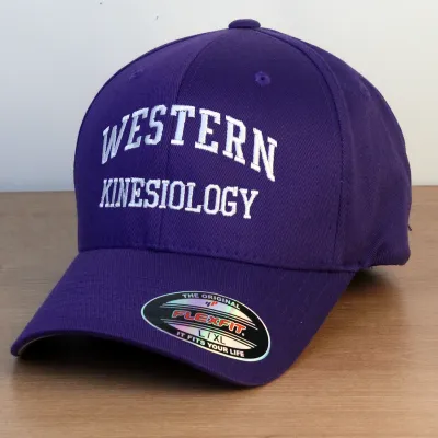 Purple ball cap with Western Kinesiology embroidered onto the front in white lettering.