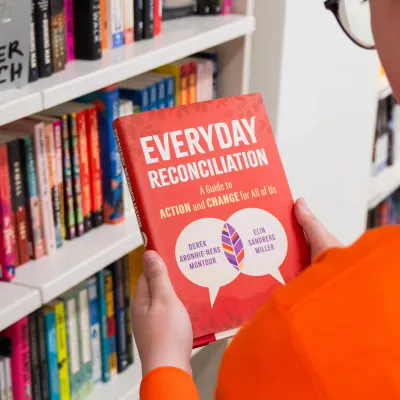 Woman holding "Everyday Reconciliation" Book