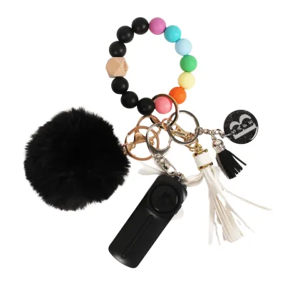 Safety keychain with accessories and pride rainbow bracelet. 
