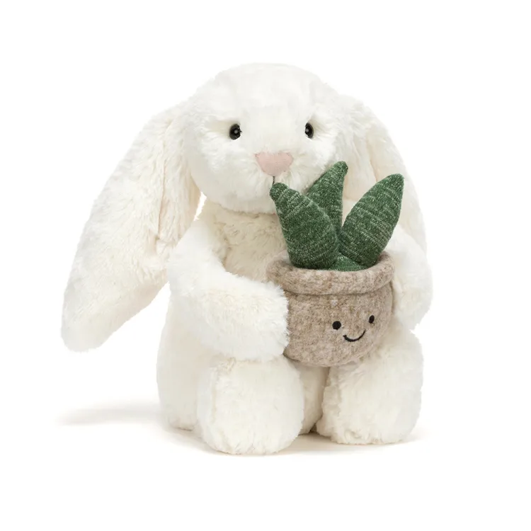 cream bunny holding potted snake plant