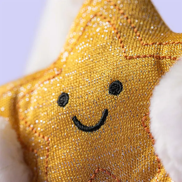 Close up of yellow plush star being held by a bunny