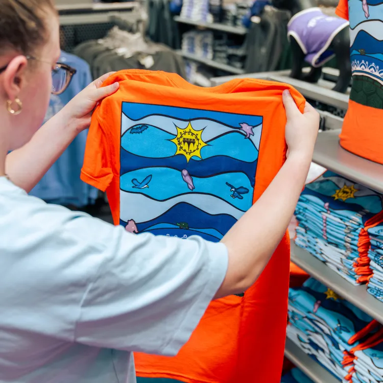 Woman holding up orange truth and reconciliation shirt