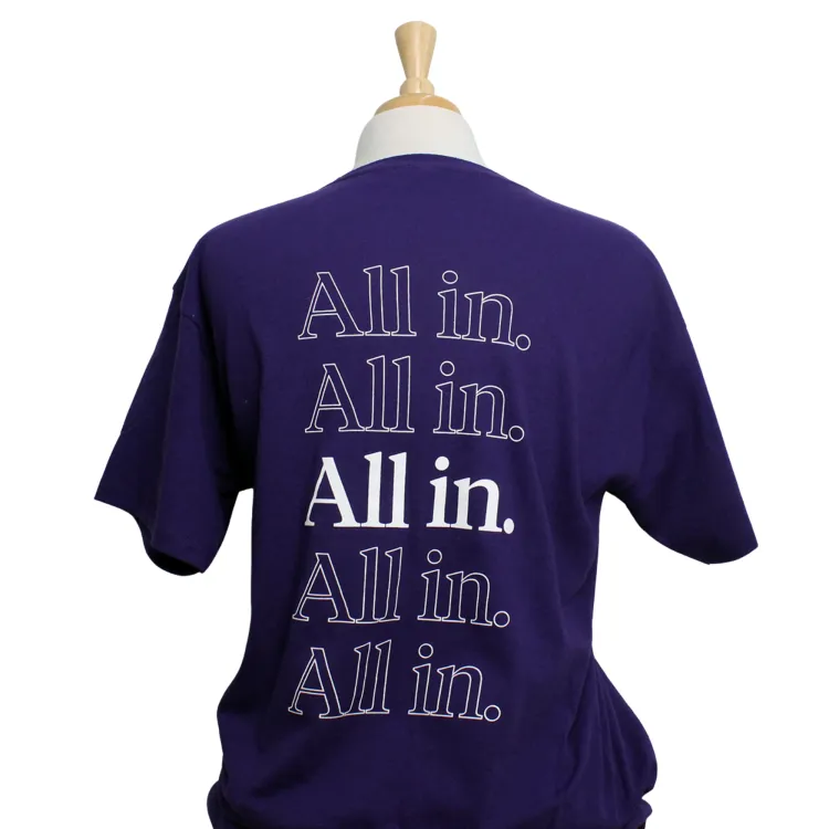 Purple tee with Western Crest logo printed on the left chest and "All In." script graphic on the back. 