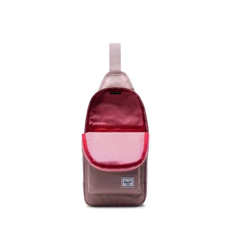 Muted pink Herschel heritage shoulder bag with front pocket.