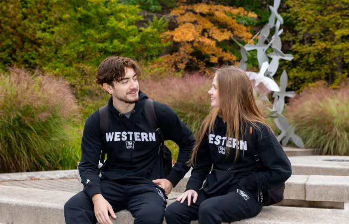 A man and woman wearing western branded athletic wear