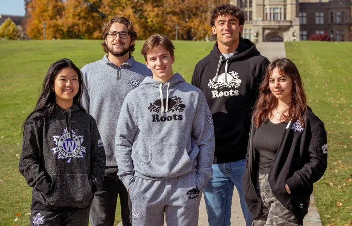 A group of people wearing roots branded attire