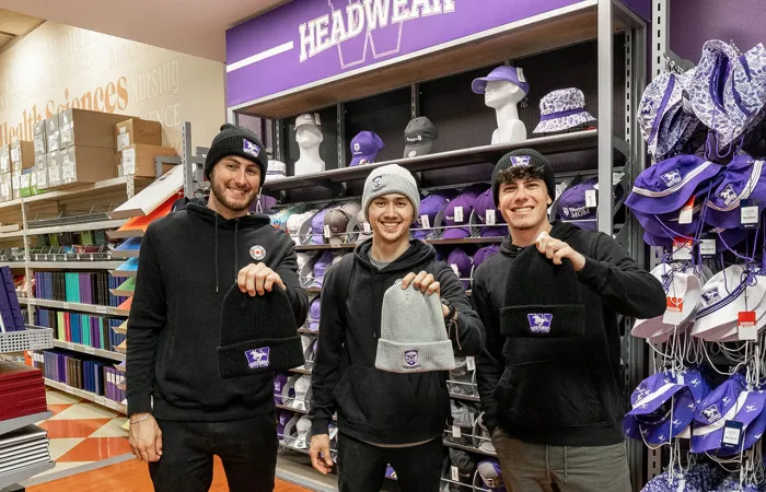 Three men showing western branded touques