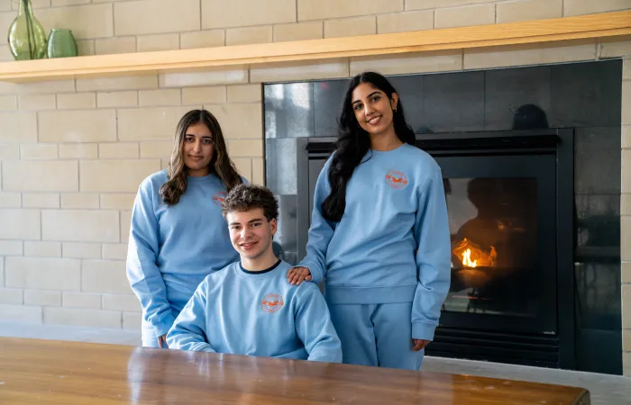 three students wearing Perth Hall residence crewnecks and joggers 