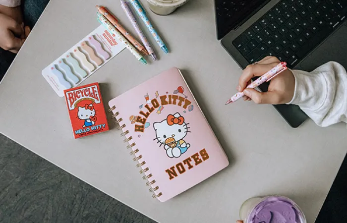hello kitty notebook with accessories and a MacBook