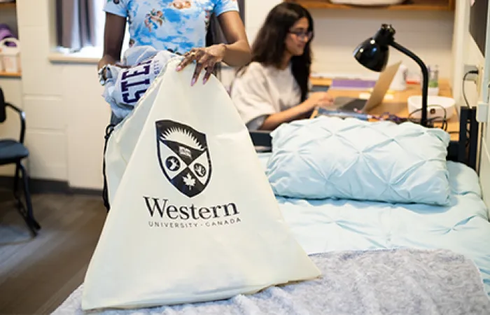 A student putting a sweater in a laundry bag