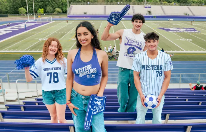 Models posed in a football stadium stand