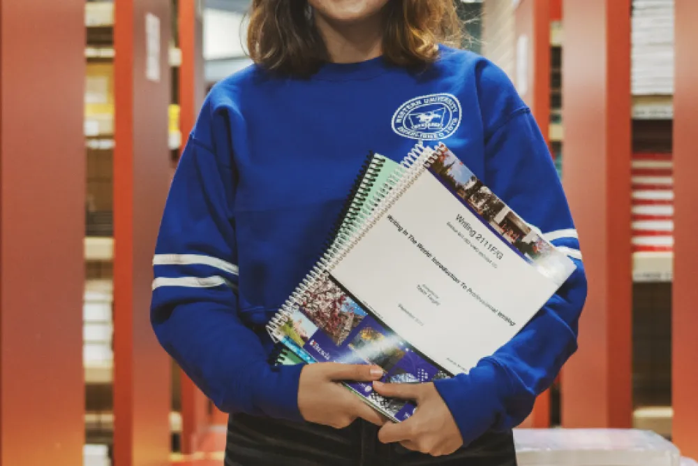 Student holding custom course books
