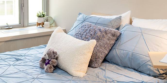 Bed with linens, pillows and Western stuffie