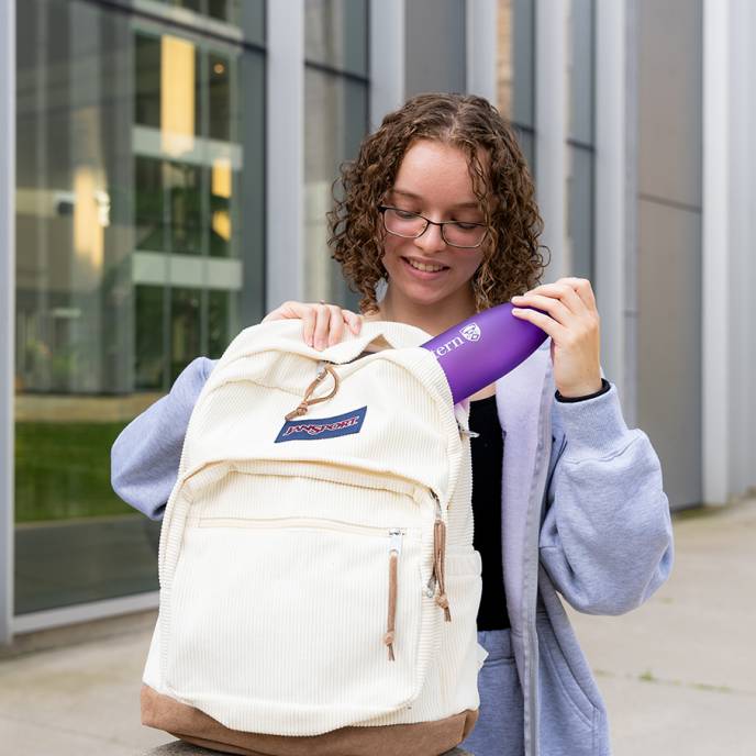 Student putting Western water bottle into backpack