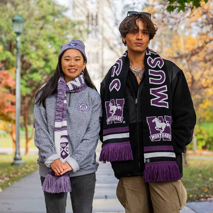 Two students wearing fall essentials