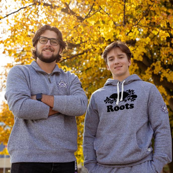 Two Western students wearing Roots // Western merch