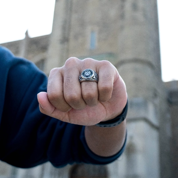 closed fist of student wearing a graduate ring